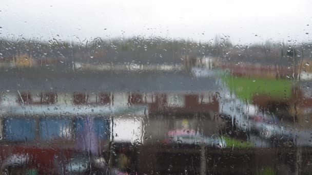 Gotas de lluvia en el cristal de la ventana en la temporada de monzones. Gotas de agua fluyen por el fondo borroso de la naturaleza, tiro estático. El clima exterior es malo. Otoño o primavera aguaceros del día lluvioso. Depresión, concepto de melancolía — Vídeos de Stock