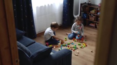 Oyun Salonundaki İki Mutlu Anaokulu Kardeşleri Çocuk Kız Çocuğu. Ev inşaatında aynı yaştaki çocuklar tahta oyuncaklarla oynarlar. Bebek evde çok zaman geçirdi. Çocukluk, Ebeveynlik, Arkadaşlık Konsepti