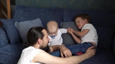 Şefkatli Kafkasyalı Genç Baba Sevimli Oğul Sevecen Küçük Çocuğu Kucaklıyor. Mutlu Sevecen Uzun Sakallı Baba Kucaklayan Bebek Kız Kız Evdeki Koltukta Oturuyor