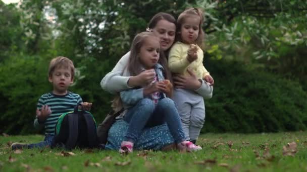 Happy family mom Three little siblings kids have fun blowing bubbles enjoying summer holidays in garden park. Smiling parents children spending leisure time together evening sunset Motherhod Mother — Wideo stockowe