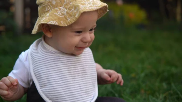 Happy Baby Sitzen mit Fußball schwarz weiß klassischen Ball auf grünem Gras. Liebenswertes Baby spielt draußen im Garten im Hinterhof. Kleine Kinder mit Eltern. Fußball, Meisterschaft, Sportkonzept — Stockfoto