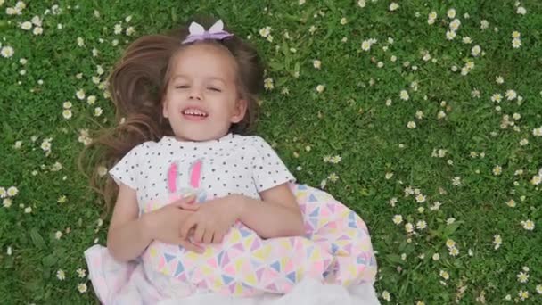Маленька Щаслива Дівчинка Сукні Бантом Голові Лежить Зеленому Газоні Парку — стокове відео
