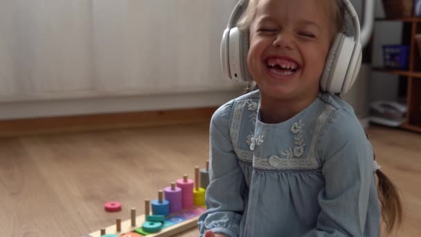 Музыка Детей Больших Белых Наушниках Счастливая Маленькая Дошкольная Беззубая Девочка — стоковое видео