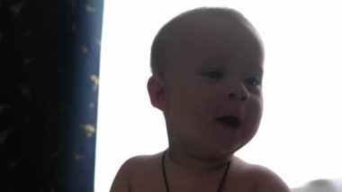 Top View 'da 10 aylık tatlı bir çocuk. Beyaz yumuşak karyolada banyo yaptıktan sonra kameraya bakıyor. Bebek, uzayı kopyalamadan önce uyanır. Çocukluk, Annelik, Aile, Bebek Konsepti