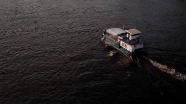 Üst hava manzaralı balıkçı teknesi okyanusu. Gün batımında Dnipro nehrinde balıkçıyla motorlu tekne gezintisi. Şehirdeki göllerin üzerindeki köprü manzarası. Su taşımacılığı, seyahat, yaz, dinlenme, rezervuarlar.