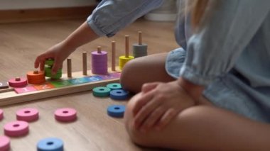 Renkli ahşap oyuncaklarla oynayan Dişsiz Mutlu Anaokulu Kızı. Sevimli çocuklar saymayı evde numara öğreterek öğreniyorlar. İçerideki Çocuk Elleri Yapımcısı 'nı kapatın. Çocukluk