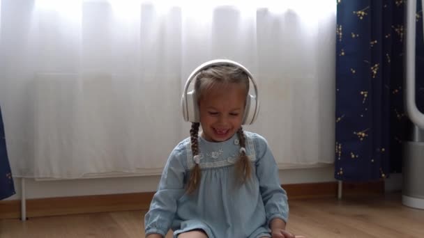 Słuchanie Muzyki Dużych Białych Słuchawkach Happy Little Przedszkola Szczerbatek Dziewczyna — Wideo stockowe
