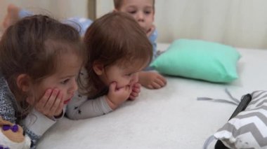 Gülen Anaokulu Bebeği Pijamalı Çocuklar Yatakta Akıllı Telefon 'da çizgi film izliyor. Kardeşler Küçük İkiz Oğlan ve Kız Eğleniyor. Evde karantinada mutlu çocuklar. Arkadaşlık, Aile, Eğitim