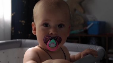 Top View 'da 10 aylık tatlı bir çocuk. Beyaz yumuşak karyolada banyo yaptıktan sonra kameraya bakıyor. Bebek, uzayı kopyalamadan önce uyanır. Çocukluk, Annelik, Aile, Bebek Konsepti