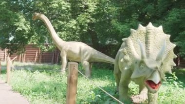 2021.08.12 - Kiev, Ukrayna: Motorize Dinazor Avcısı Triceratops ve Eğlence Ormanı Parkı 'nda Brachiosaurus Mockup. Dinopark 'taki Jurassic Tarih Öncesi Dönemin Hareket Eden Modelleri Sergisi.