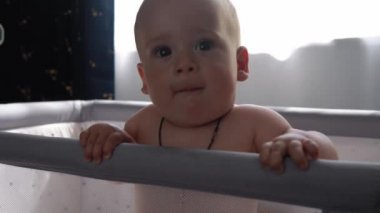 Top View 'da 10 aylık tatlı bir çocuk. Beyaz yumuşak karyolada banyo yaptıktan sonra kameraya bakıyor. Bebek, uzayı kopyalamadan önce uyanır. Çocukluk, Annelik, Aile, Bebek Konsepti