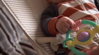 Çocukluk, annelik, aile, rahatlık. Çizgili pijamalı yeni doğmuş bebek uyandı. Etrafındaki her şeye baktı. Gülümsemeler çıngıraklı yılanlarla oynuyor..
