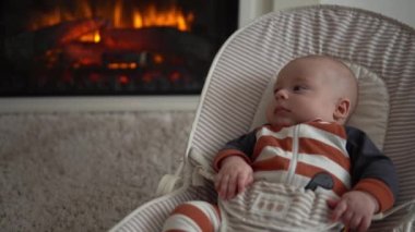Kameradaki bebeğe bakmak, çocukluk, aile sevgisi. Çizgili elbiseli şirin gülen yüz uyandı. Evdeki şöminenin yanındaki sandalyeye uzandı. Neşeli yaşam tarzı mutlu çocuk..