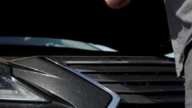 Hüsrana uğramış adam kaza arabasını tamir ediyor. Bozuk Arabadaki Üzücü Erkek. Araç Kontrol Motoru Hasar Sorunları. Şoför Acil Servis 'i arıyor. Otomobil kazası. Hood Otomobil Aç.
