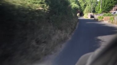 Güneşli bir günde Yeşil Ağaçlar 'ın arasından. Araba penceresinden yola, ışıldayan sokaklara ve binalara. Vahşi Doğa Gezisi. Ulaştırma, Seyahat, Meslek, Turizm Konsepti