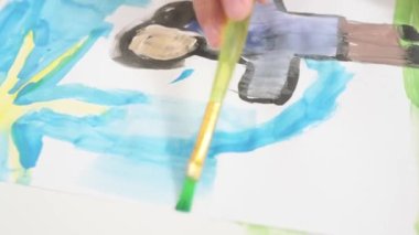 Close up Talented little girl Female Artist Draws Mother Sun Summer Flover drawing at Home. Colorful, Emotional Happy painting with Brush water colors. Contemporary Painter Creating Abstract Modern
