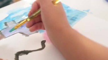 Close up Talented little girl Female Artist Draws Mother Sun Summer Flover drawing at Home. Colorful, Emotional Happy painting with Brush water colors. Contemporary Painter Creating Abstract Modern