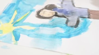 Close up Talented little girl Female Artist Draws Mother Sun Summer Flover drawing at Home. Colorful, Emotional Happy painting with Brush water colors. Contemporary Painter Creating Abstract Modern