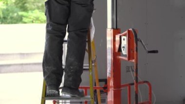Hard male work on construction site. Two professional workers in special uniforms Contractors Safety Hats repairing ceiling wall inside building. Builders equipment at workplace. industrial premises.