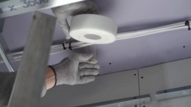 Hard male work on construction site. professional worker in special uniforms Contractors Safety Hats repairing ceiling wall inside building. Builders equipment at workplace. industrial premises.