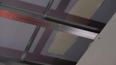 Hard male work on construction site. professional worker in special uniforms Contractors Safety Hats repairing ceiling wall inside building. Builders equipment at workplace. industrial premises.