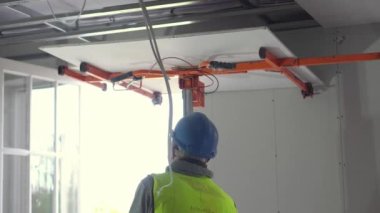 Hard male work on construction site. Two professional workers in special uniforms Contractors Safety Hats repairing ceiling wall inside building. Builders equipment at workplace. industrial premises.