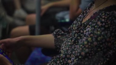 Close shot of young attractive Ukraine female in glasses sitting on moving city metro train. Woman calling typing text message on mobile phone. Pretty Lady waving hands say goodbye. Traveling alone.