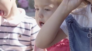 Three cute little Children enjoys delicious ice cream cone. Child eating watermelon popsicle. Kids Siblings snack sweets in Home Garden. Summer holiday Hot weather Sunny Day. Childhood, Food Candy.
