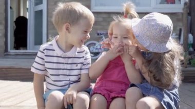 Three cute little Children enjoys delicious ice cream cone. Child eating watermelon popsicle. Kids Siblings snack sweets in Home Garden. Summer holiday Hot weather Sunny Day. Childhood, Food Candy.