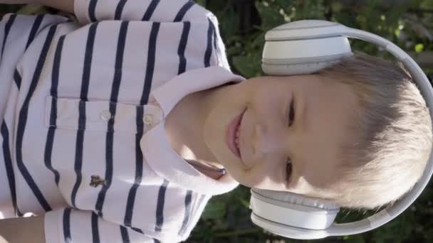 Κάθετη Shot Πορτρέτο Του Χαριτωμένο Μικρό Αγόρι Λευκά Ακουστικά Ακούγοντας — Αρχείο Βίντεο
