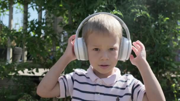 Portrait Cute Little Boy Headphones Listening Music Cheerful Carefree Childhood — ストック動画