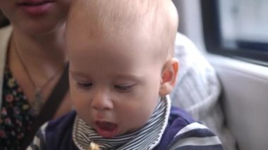 Baby snack time. Happy Mom traveling by train with her Son. Mother and child. Traveling with children. traveling the world Infant rides rain, looks out the window, enjoying the scenery. Paternhood