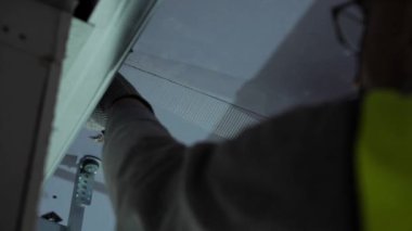 Hard male work on construction site. professional worker in special uniforms Contractors Safety Hats repairing ceiling wall inside building. Builders equipment at workplace. industrial premises.