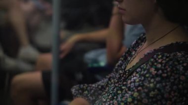 Close shot of young attractive Ukraine female in glasses sitting on moving city metro train. Woman calling typing text message on mobile phone. Pretty Lady waving hands say goodbye. Traveling alone.