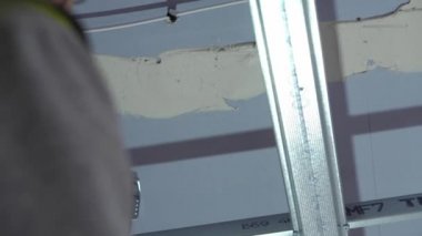 Hard male work on construction site. professional worker in special uniforms Contractors Safety Hats repairing ceiling wall inside building. Builders equipment at workplace. industrial premises.