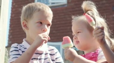 Three cute little Children enjoys delicious ice cream cone. Child eating watermelon popsicle. Kids Siblings snack sweets in Home Garden. Summer holiday Hot weather Sunny Day. Childhood, Food Candy.