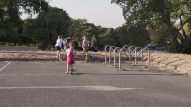 Three sisters brother playing riding a bike in park.Siblings have fun ride a scooter outside. happy family kids dream concept. children together in lifestyle park. Friendship, Childhood sunset Sport.