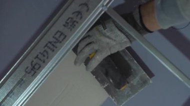 Hard male work on construction site. professional worker in special uniforms Contractors Safety Hats repairing ceiling wall inside building. Builders equipment at workplace. industrial premises.