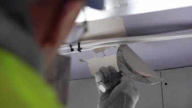 Hard male work on construction site. professional worker in special uniforms Contractors Safety Hats repairing ceiling wall inside building. Builders equipment at workplace. industrial premises.