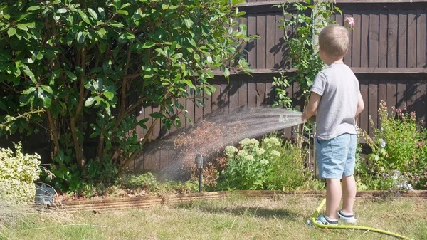Забавный Мальчик Поливает Газоны Заднем Дворе Очаровательный Ребенок Играет Шлангом — стоковое фото