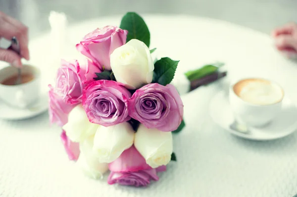 Mooi boeket bloemen op een tafel met kopjes koffie — Stockfoto