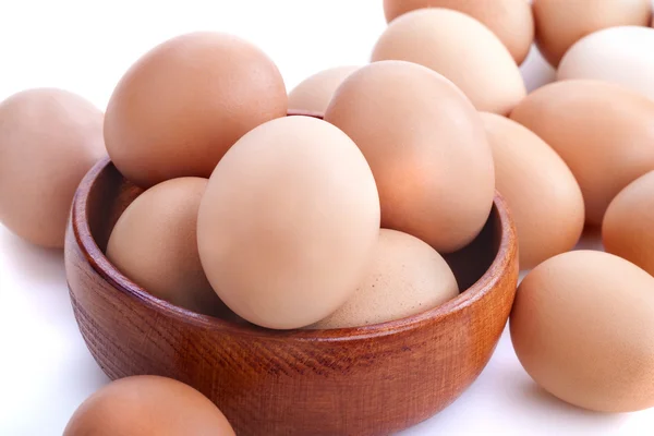 Huevos en un tazón de madera —  Fotos de Stock