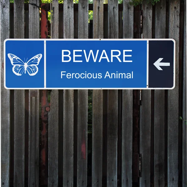 Cuidado com o sinal azul horizontal na cerca de madeira velha — Fotografia de Stock