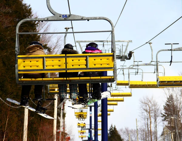 Snowboardziści & narciarz rodziny na wyciąg krzesełkowy — Zdjęcie stockowe