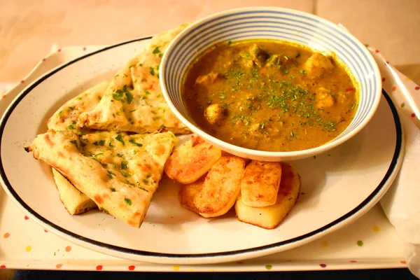 Hint usulü baharatlı tavuk, yanında sarımsaklı ekmek ve patates kızartması, evde kolay pişirilen yemek..