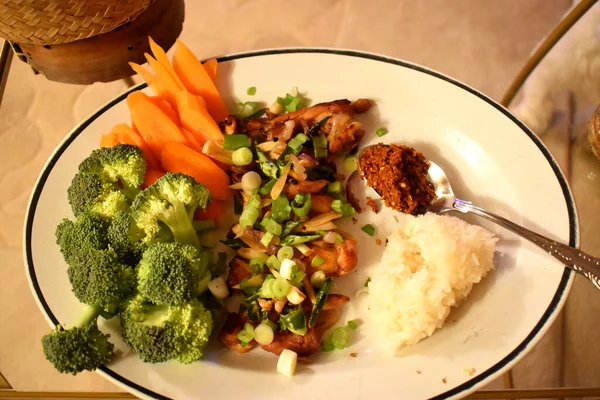 Barbekü tavuk tarifi, dilimlenmiş yeşil biber ve bebek soğanları taze organik sebze brokoli, havuç ve yapışkan pirinçle yenir. Sağlıklı yiyecekler ve Tayland yemeği tarzıyla evde kolay aşçı..