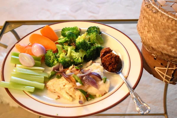 Dilimlenmiş yeşil biberli kızarmış balık ve kırmızı soğan taze ve organik sebze brokoli, havuç ve kereviz ile baharatlı biber ezmesi ile yenir. Sağlıklı yiyecekler ve evde kolay pişirme..