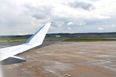 Viewed from the airplane window of an Airplane taking off from the airport with a beautiful background of green land under white clouds sky.
