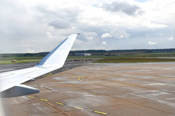 Viewed from the airplane window of an Airplane taking off from the airport with a beautiful background of green land under white clouds sky.