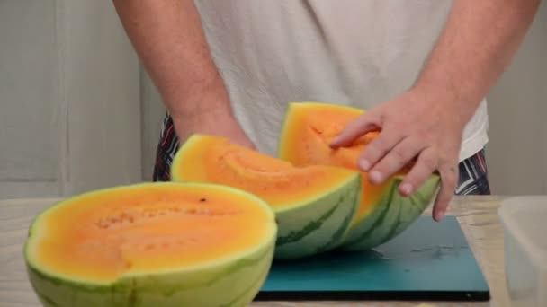 Man skär stora bitar av gula vattenmelon — Stockvideo